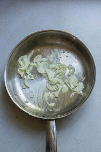 Sliced onions in a frying pan.