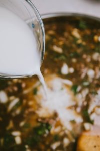 A bowl of soup is being poured with milk.