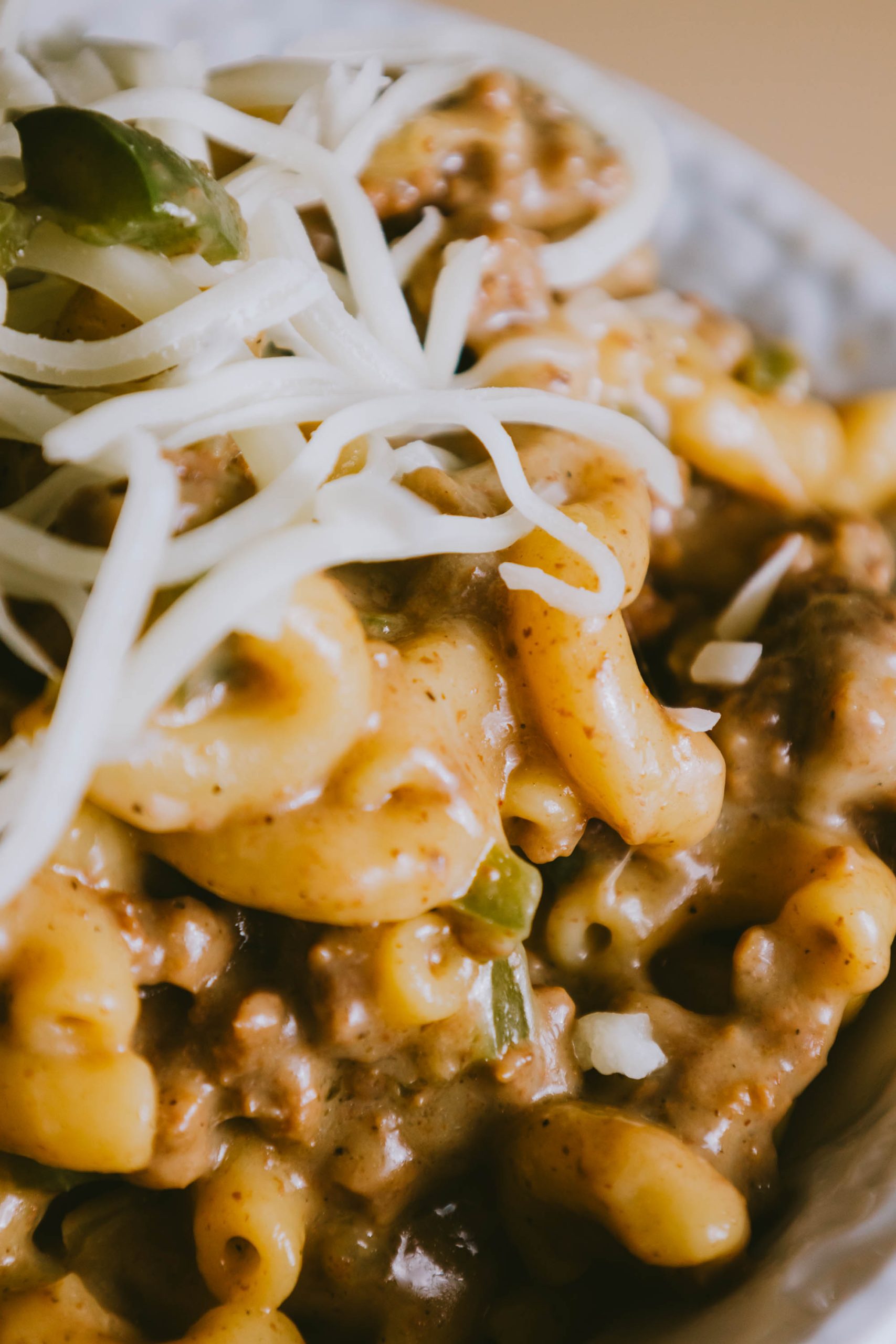 A bowl of Ground Beef Philly Cheesesteak Casserole with meat and cheese.