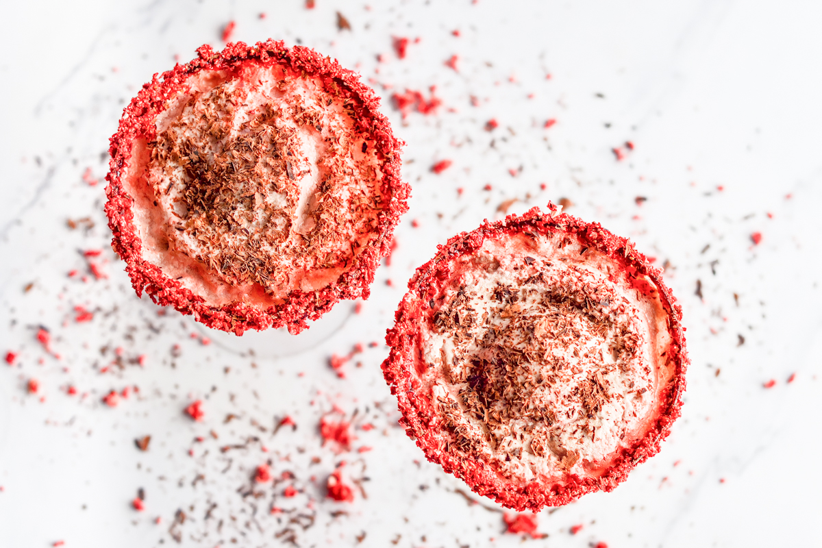 Two cups of red velvet ice cream with sprinkles on top.