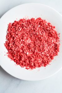 A white plate with red sprinkles on it.