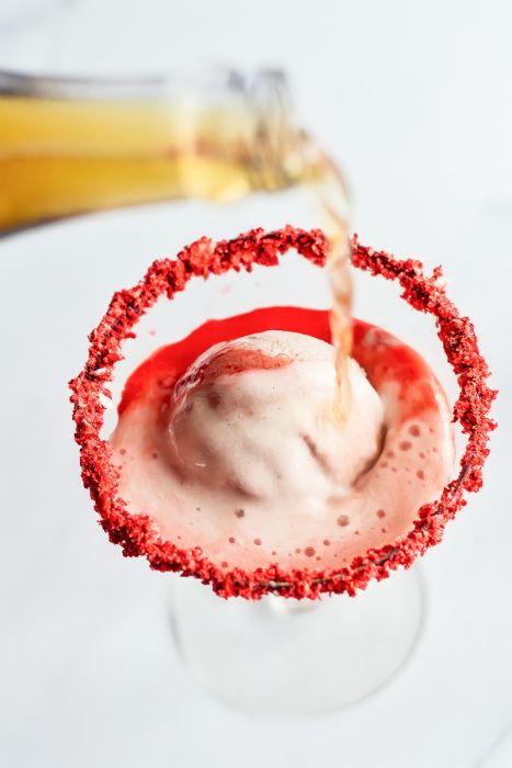 A martini being poured into a martini glass.