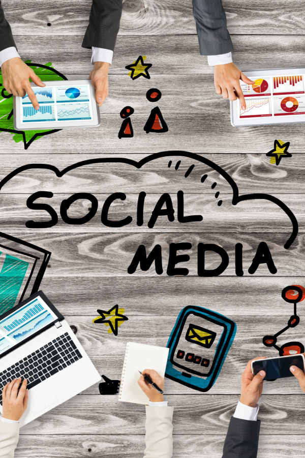 A group of people using social media on a wooden table.