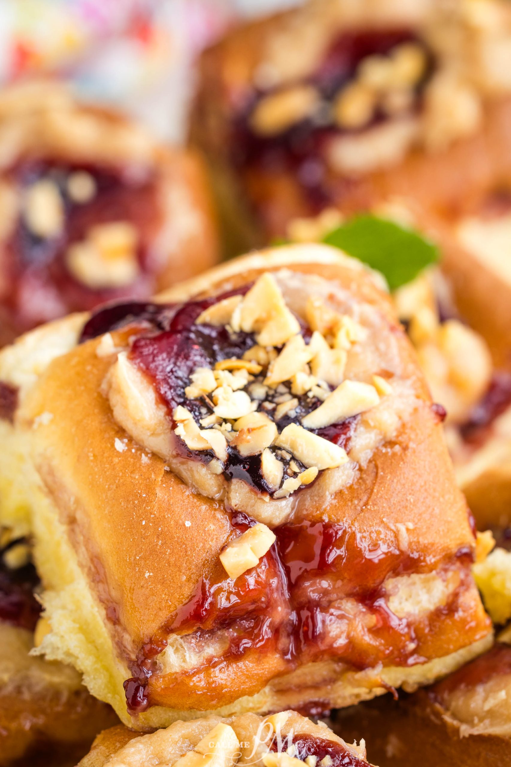 Close-up of freshly baked fruit rolls topped with crushed nuts.