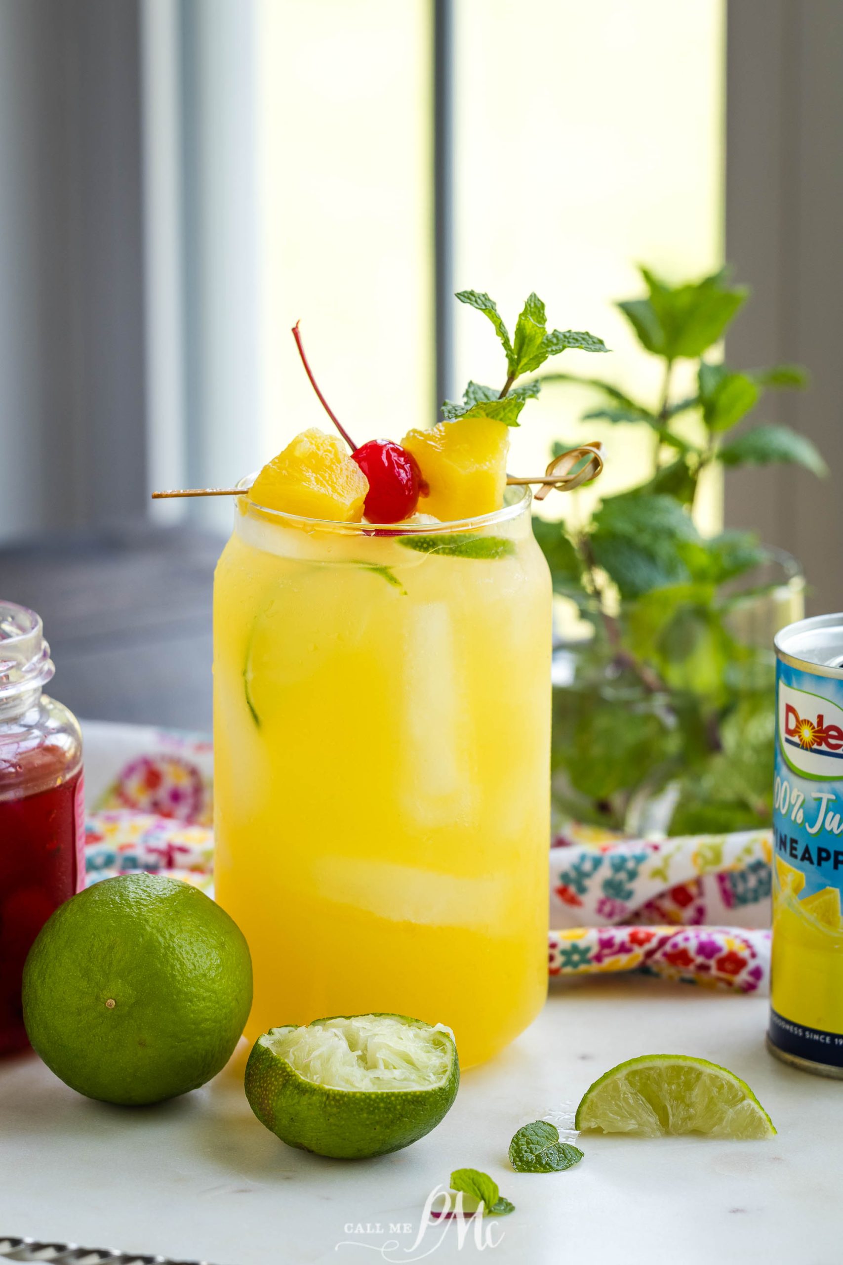 A glass of Pineapple Rum Punch recipe with fruit on a stick.