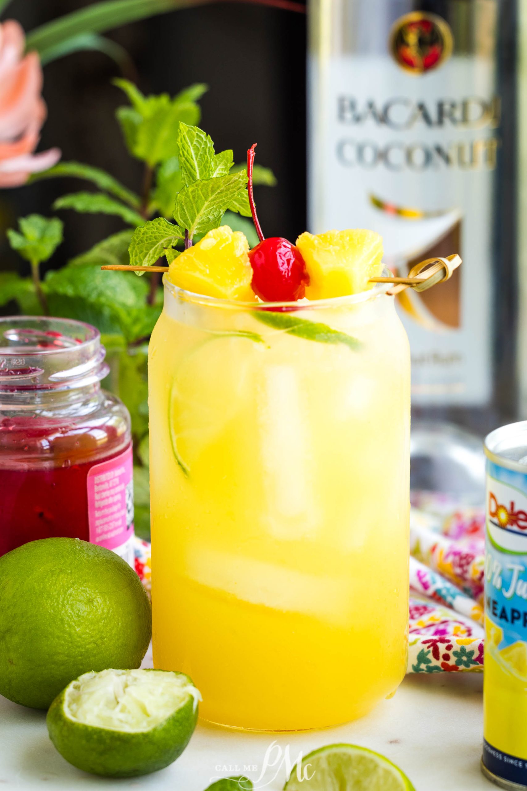 A glass of Pineapple Rum Punch recipe with fruit on top.