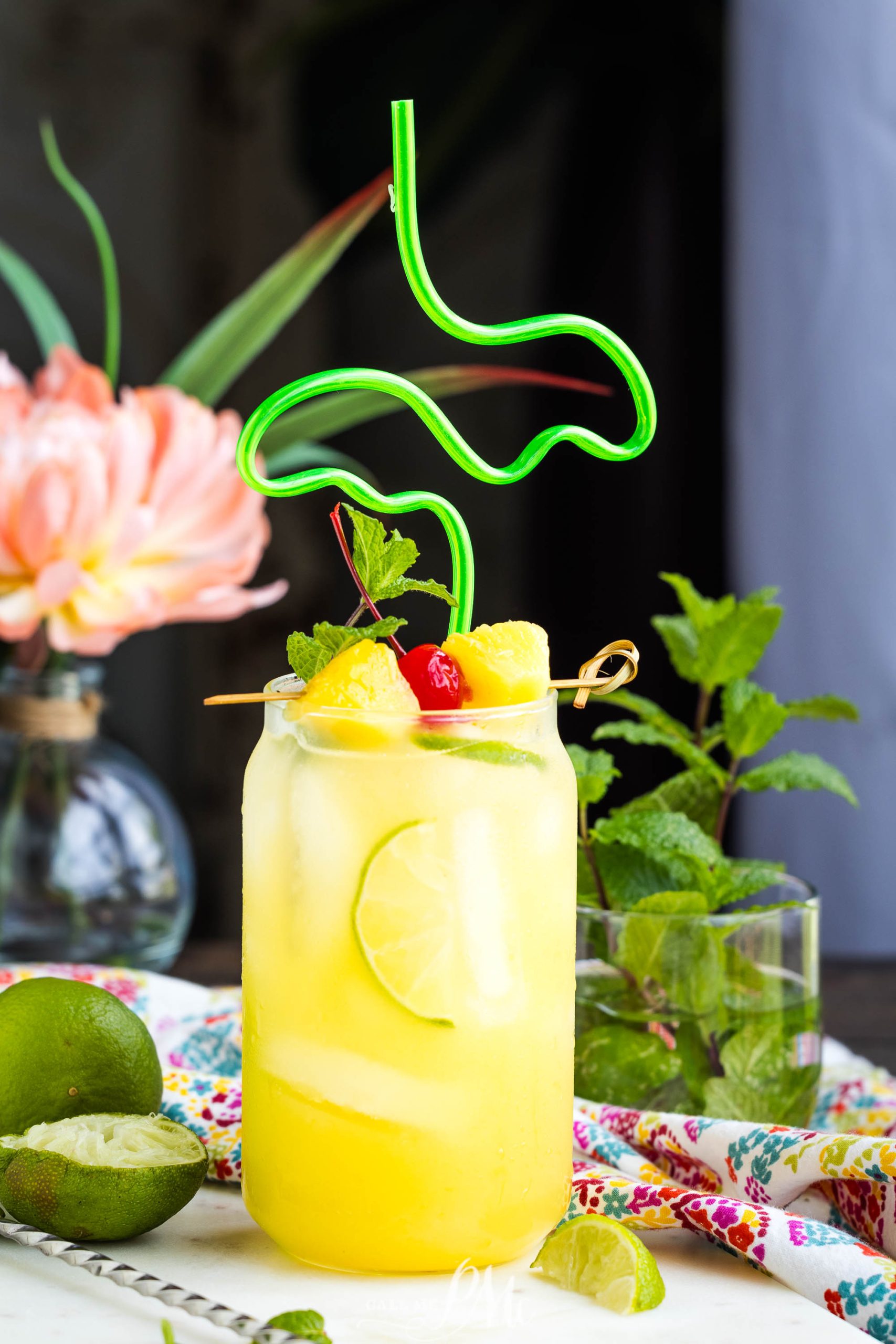 A glass of Pineapple Rum Punch recipe with fruit on top.