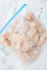 A clear resealable bag filled with sugar-coated crescent rolls on a marble surface.