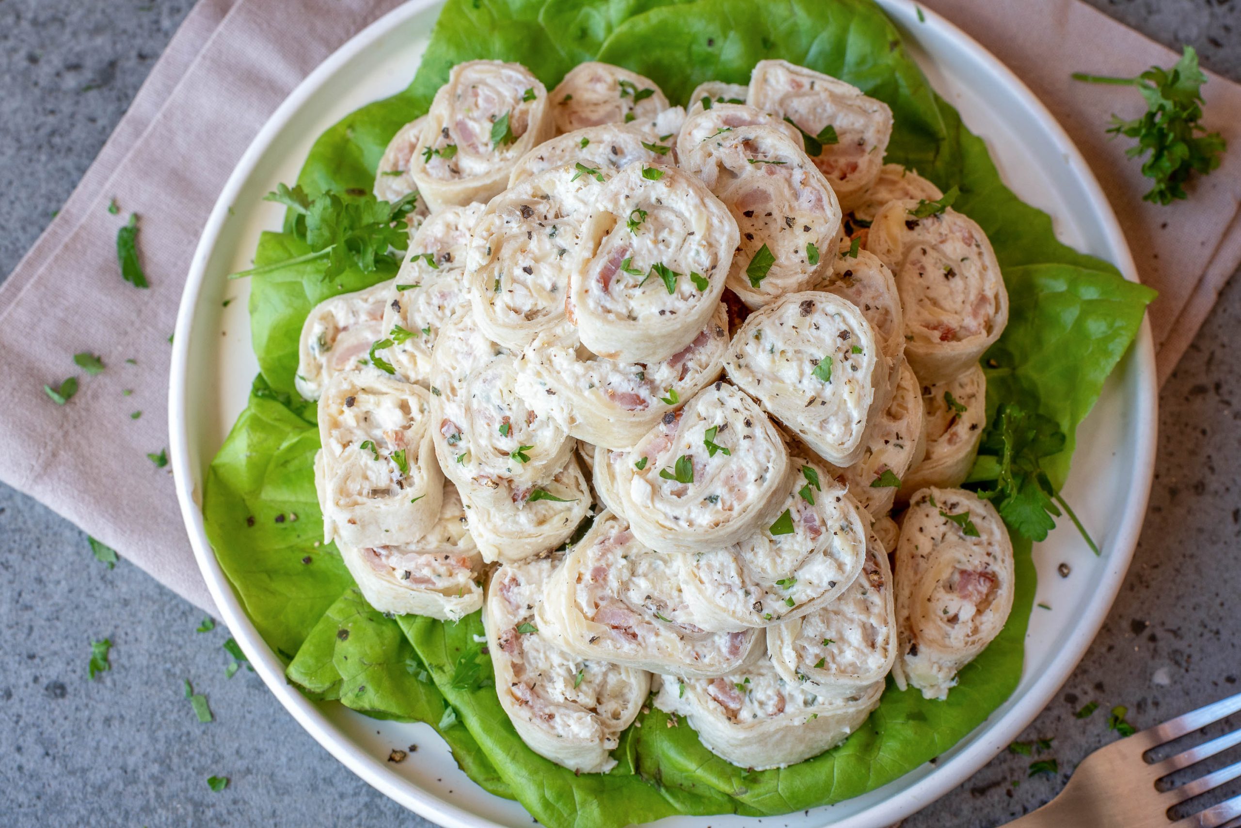 A plate of carranged on a bed of lettuce, garnished with chopped herbs.