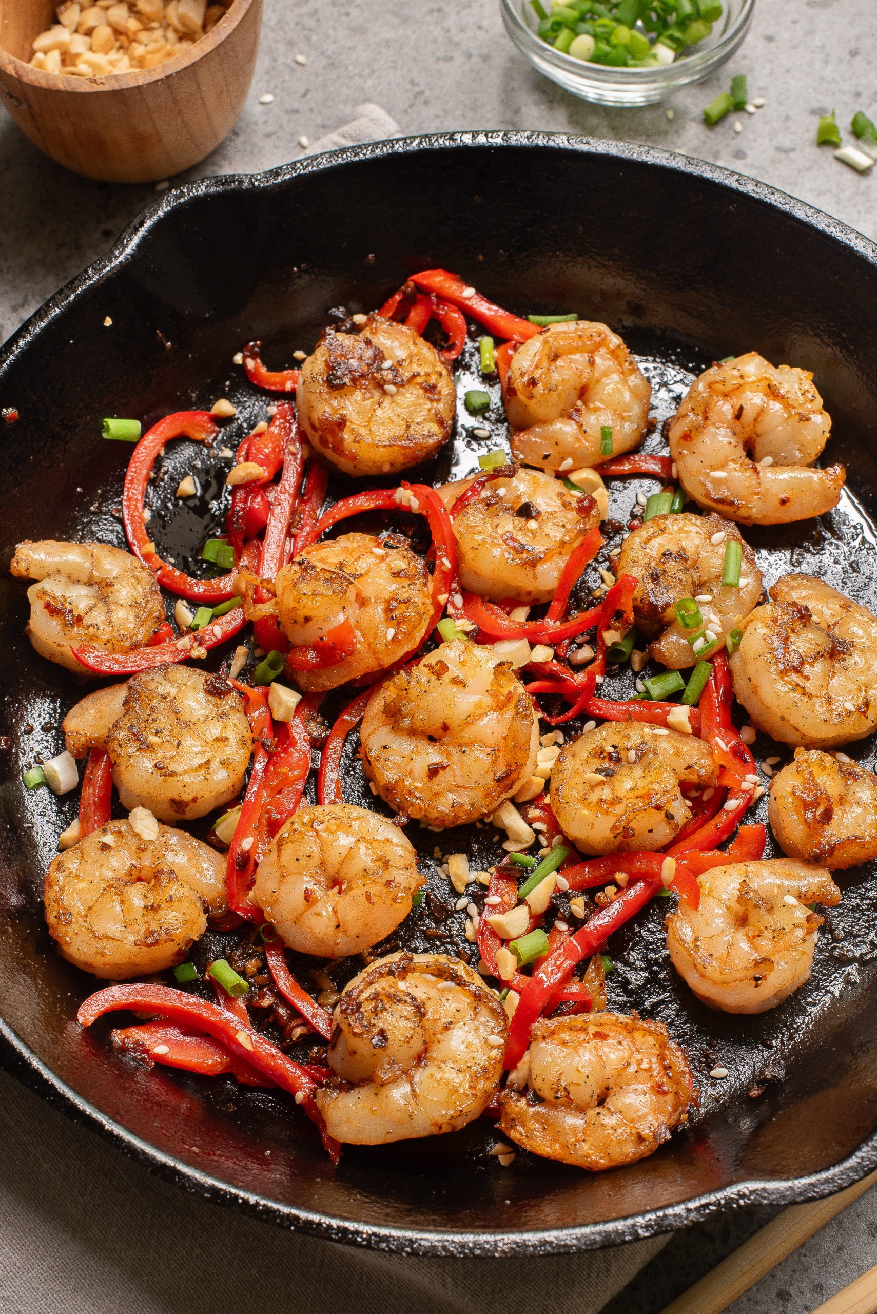 Food in a black cast-iron skillet, garnished with chopped green onions.