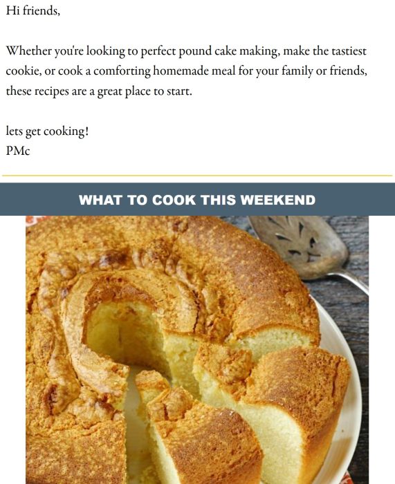 A golden brown pound cake with a cracked top sits on a plate, partially sliced, next to a metal cake server.