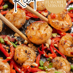 Cooked garlic shrimp with chopped green onions and red bell peppers in a skillet, with chopsticks picking up one shrimp. Text: "Low-carb Garlic Shrimp Recipe, Easy, Flavorful, Versatile.