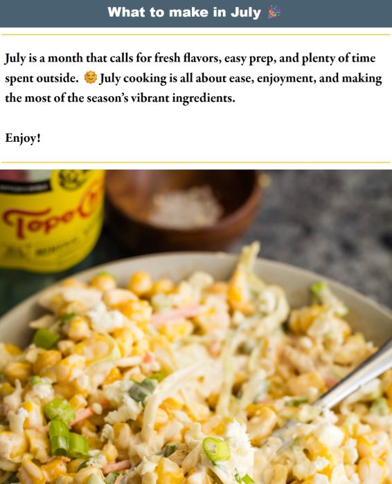 A bowl of fresh corn salad with chopped green onions sits on a table next to a bottle of Topo Chico, a small dish of salt, and a stack of email newsletters ready to be read.