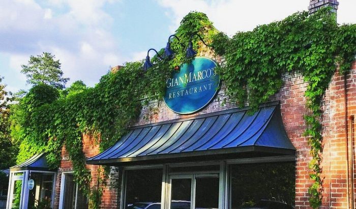 Exterior of a brick restaurant building with green ivy growing on the facade and a sign that reads "San Marco's Restaurant.