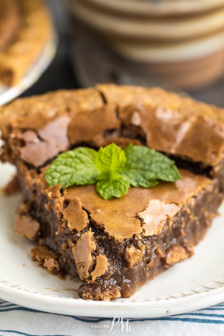 A piece of brown cake with a leaf on top.