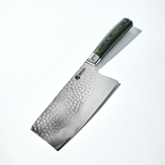 A stainless steel cleaver with a hammered finish and a green wood-patterned handle is placed on a white surface.