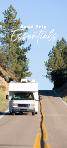A white RV cruises down a sunny, tree-lined road, capturing the spirit of adventure and freedom. "Road Trip Essentials" appears at the top, reminding travelers to pack smart for their next unforgettable journey.