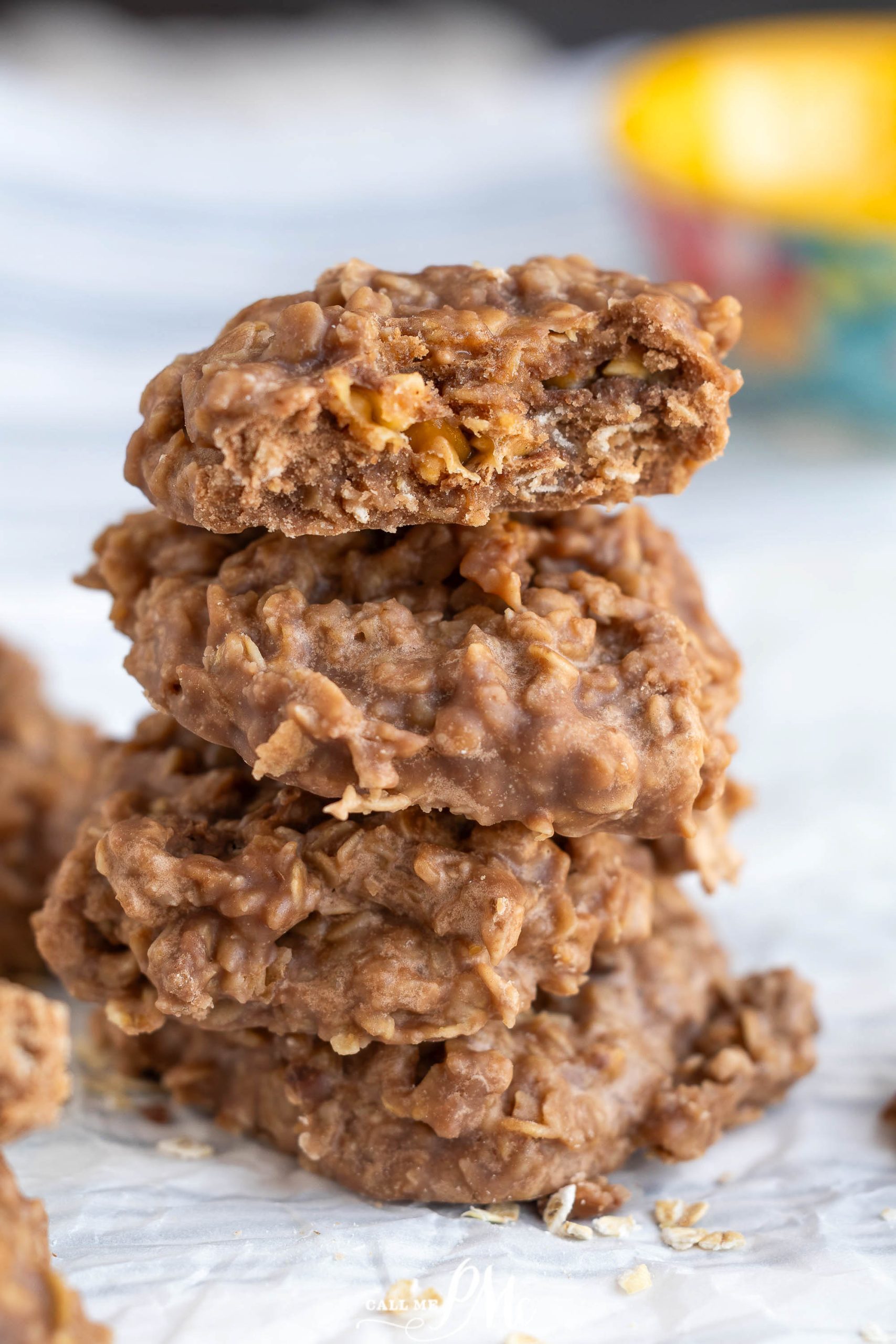 A stack of chocolate oatmeal cookies with the top cookie partially bitten, showing the chewy interior.