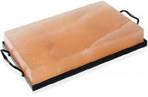 A rectangular pink Himalayan salt block with black handles on each side, placed on a black tray.