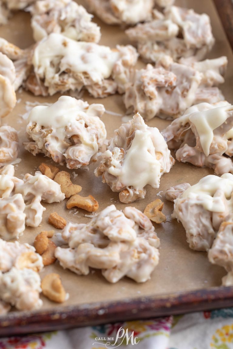 Clusters of Clodhopper Candy—white chocolate-coated snack mix—are arranged on a parchment-lined baking sheet.