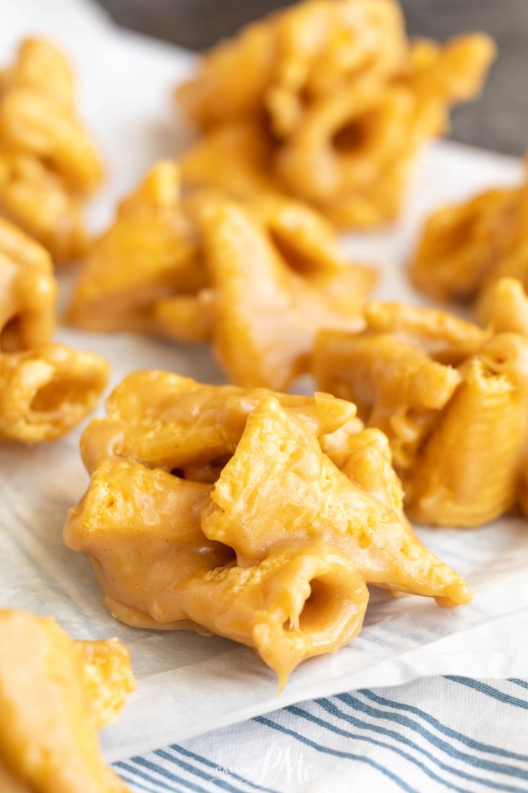 Clusters of butterscotch-coated cornflake cookies and crunchy peanut bugles are arranged on a sheet of parchment paper.