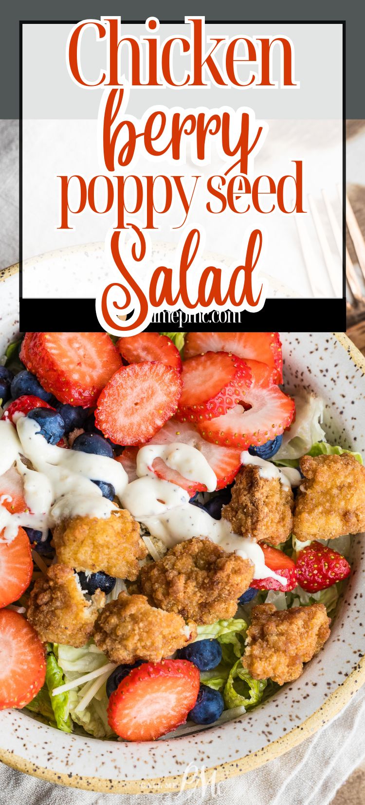 A plate of salad topped with fried chicken pieces, sliced strawberries, blueberries, and drizzled with creamy dressing.
