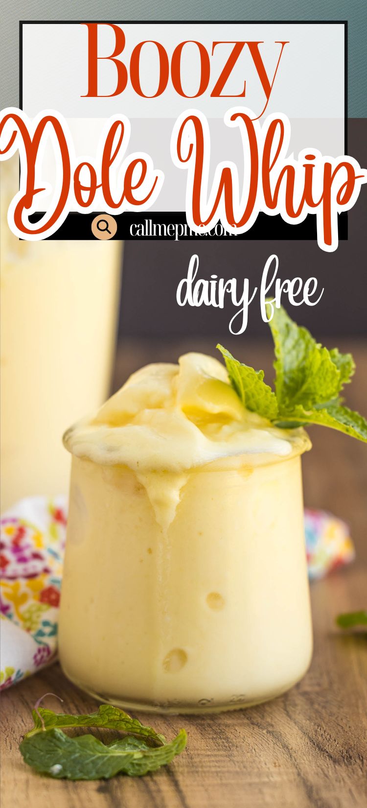 A glass of creamy yellow Dairy-Free Boozy Dole Whip topped with a sprig of mint, resting beside a floral napkin, with text overlay reading "Boozy Dole Whip dairy free.