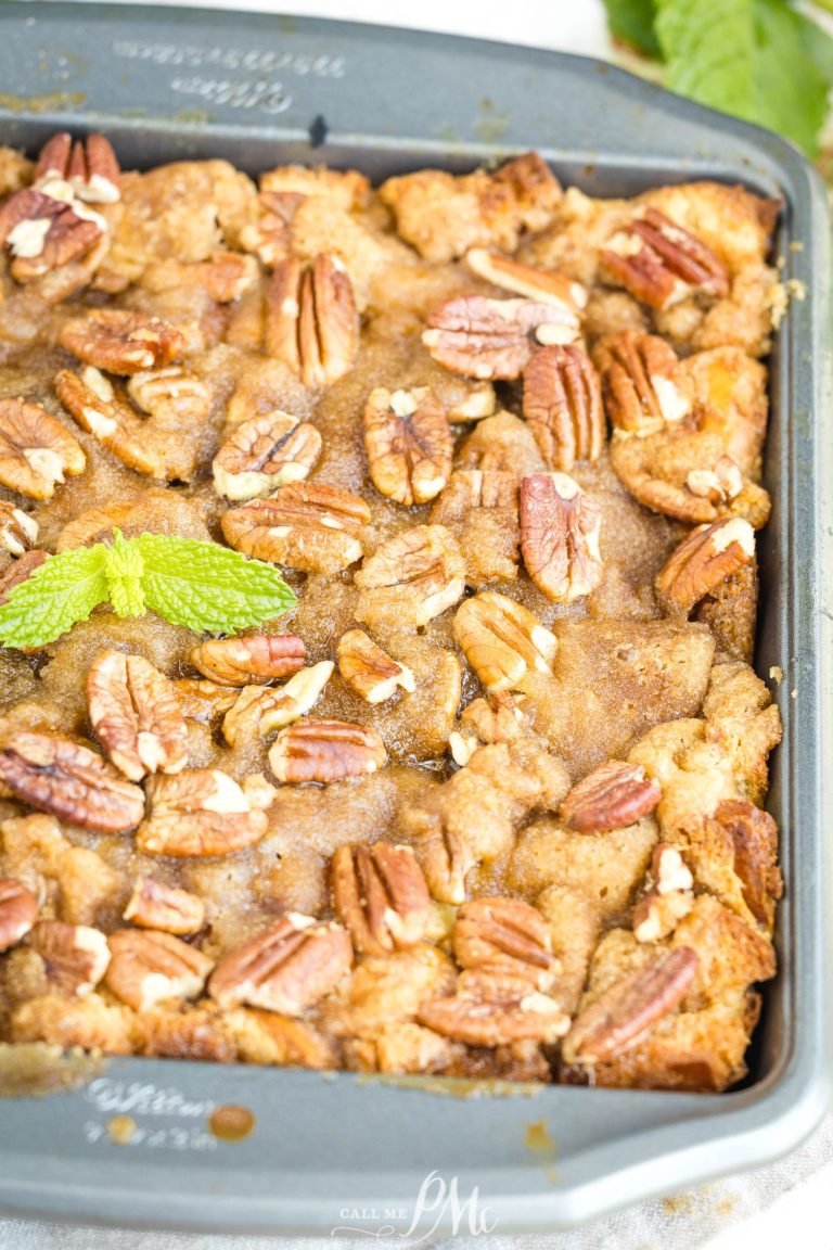 A baked dessert in a square pan topped with pecan halves and a sprig of fresh mint, featuring a golden-brown, crumbly surface.
