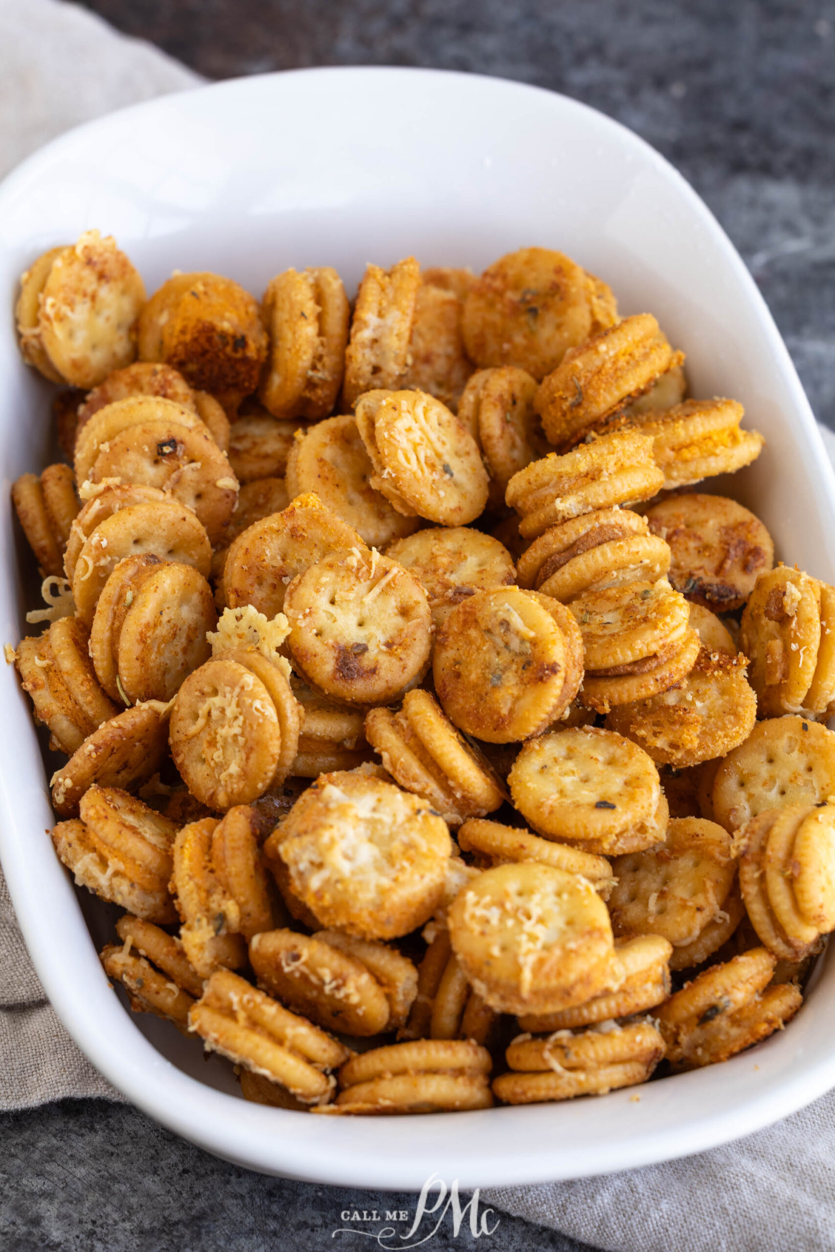 A white bowl filled with garlic bread Ritz Bits sandwiches topped with grated cheese.