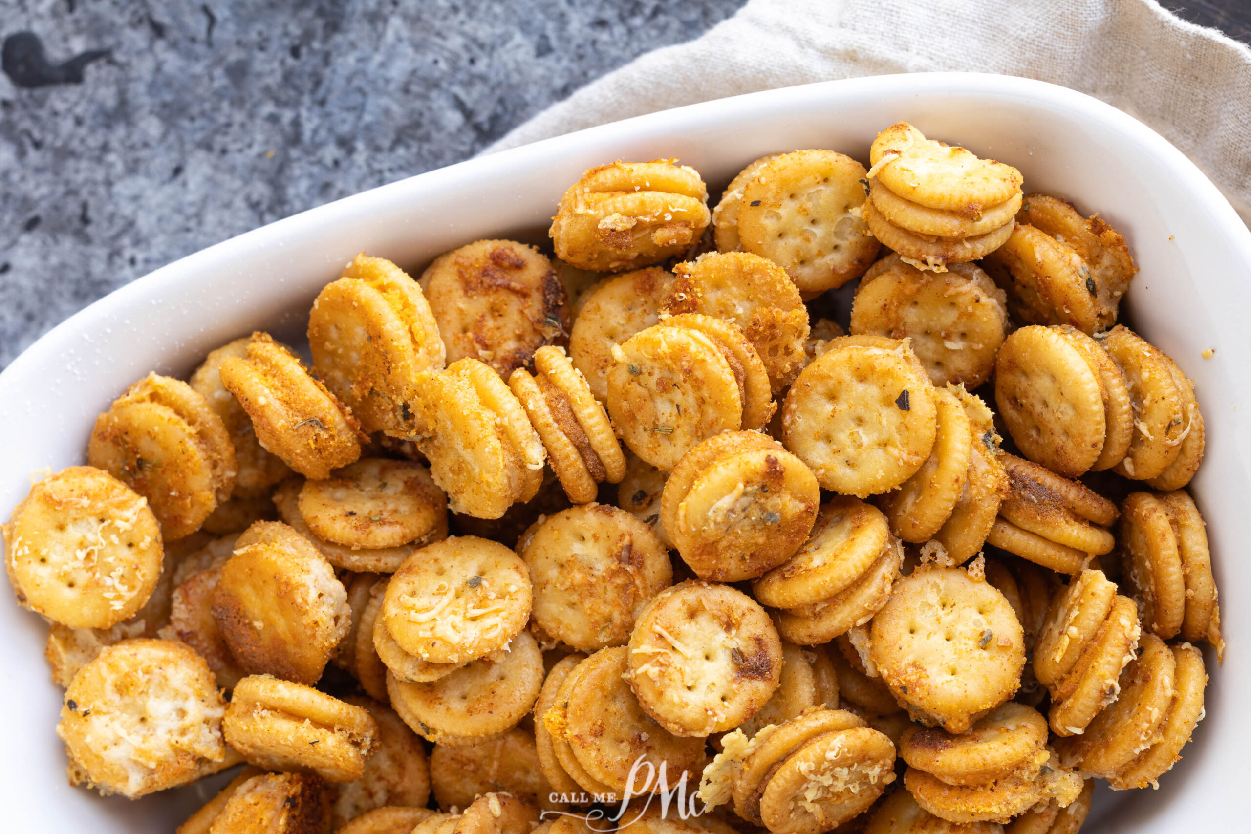 A white ceramic dish filled with golden-brown garlic bread Ritz Bits cracker sandwiches.