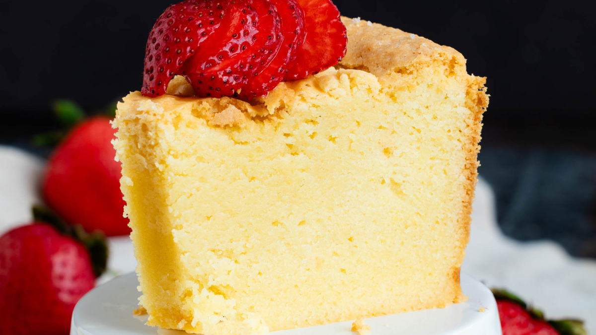 A slice of white chocolate pound cake topped with sliced strawberries.