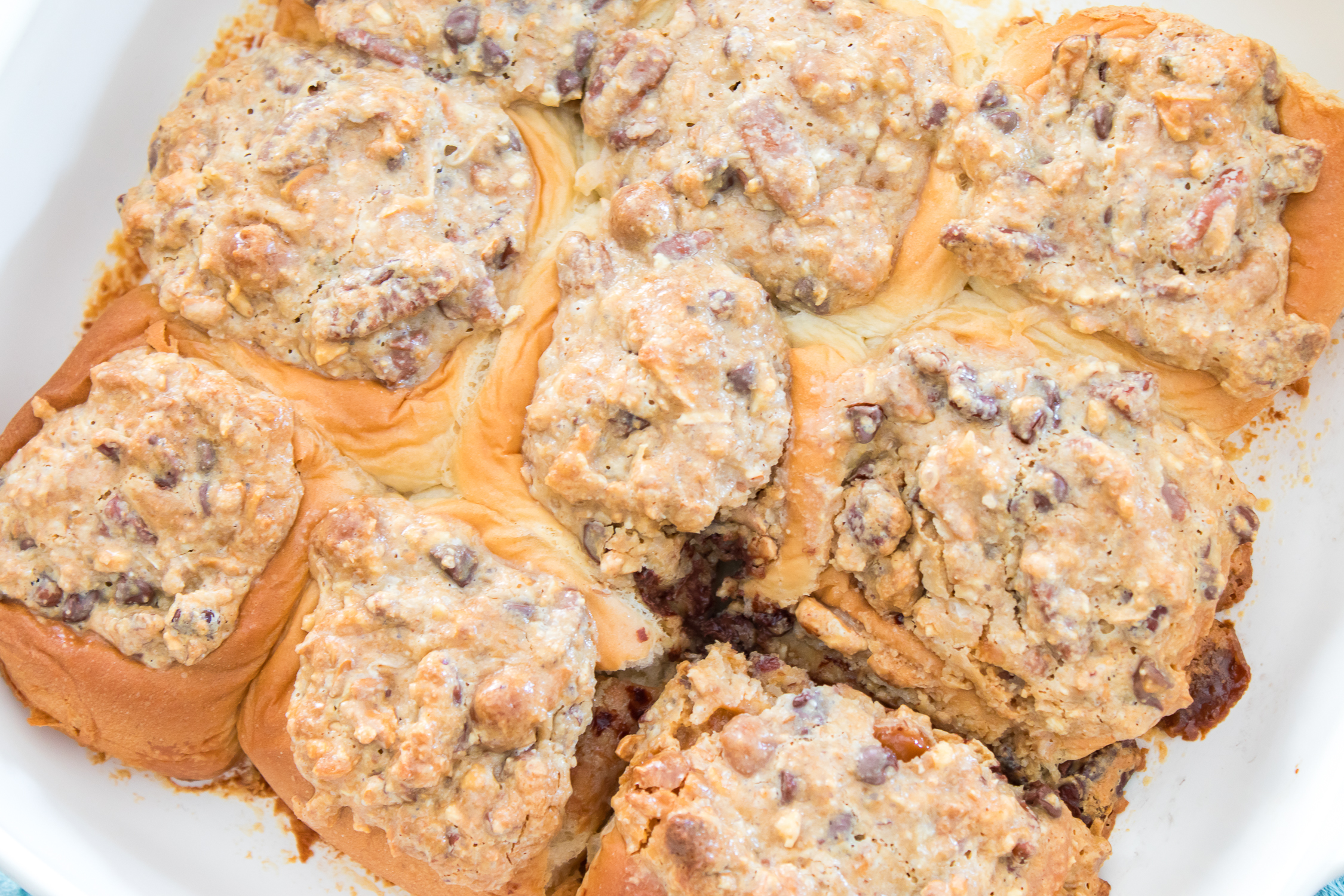 A pan of sweet rolls topped with a nut and chocolate chip streusel.